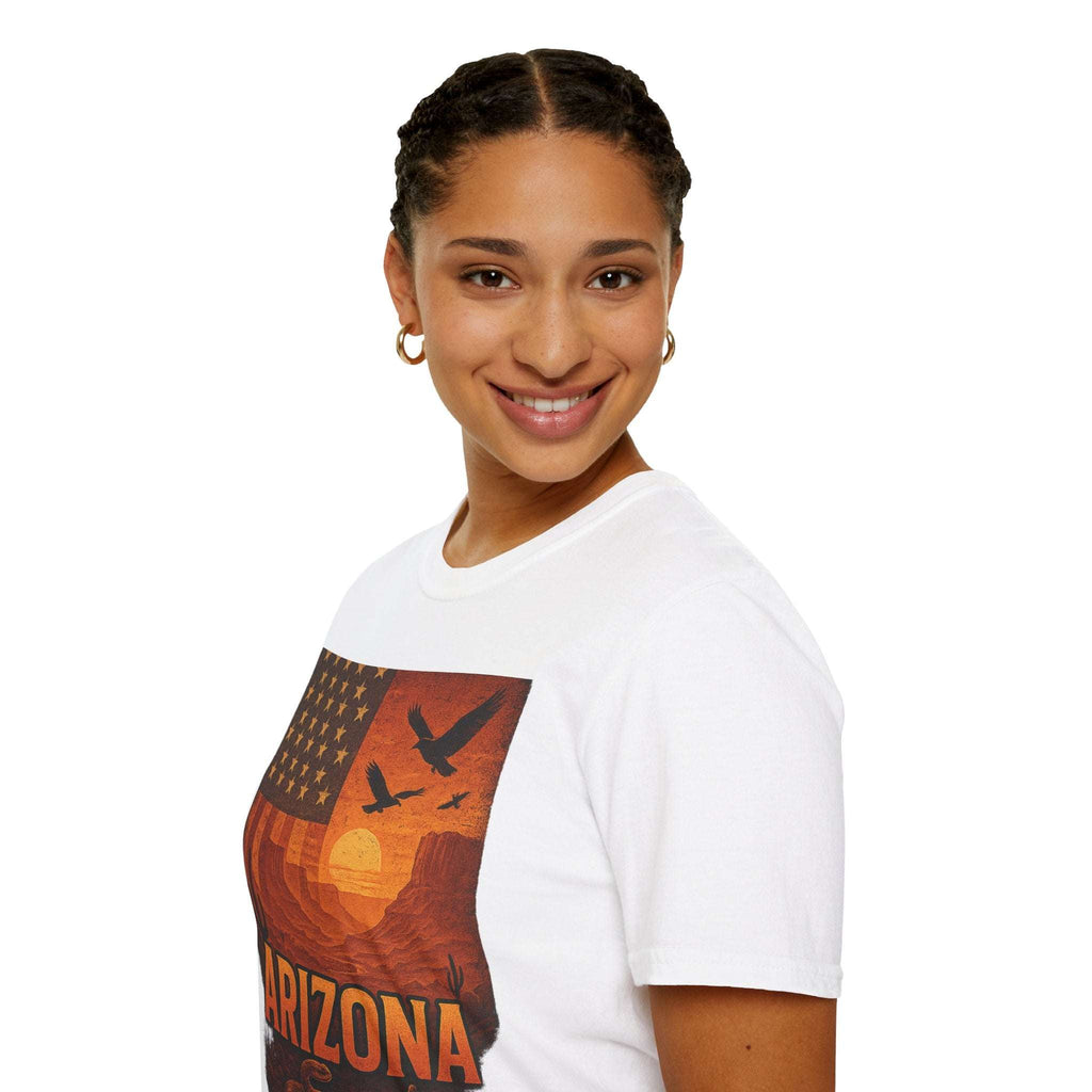 Model wearing Arizona Sunset unisex softstyle t-shirt with vintage desert graphic, smiling against a plain background.
